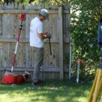 land surveyor working along fence