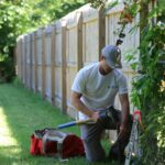 unger surveyor measuring property line at fence